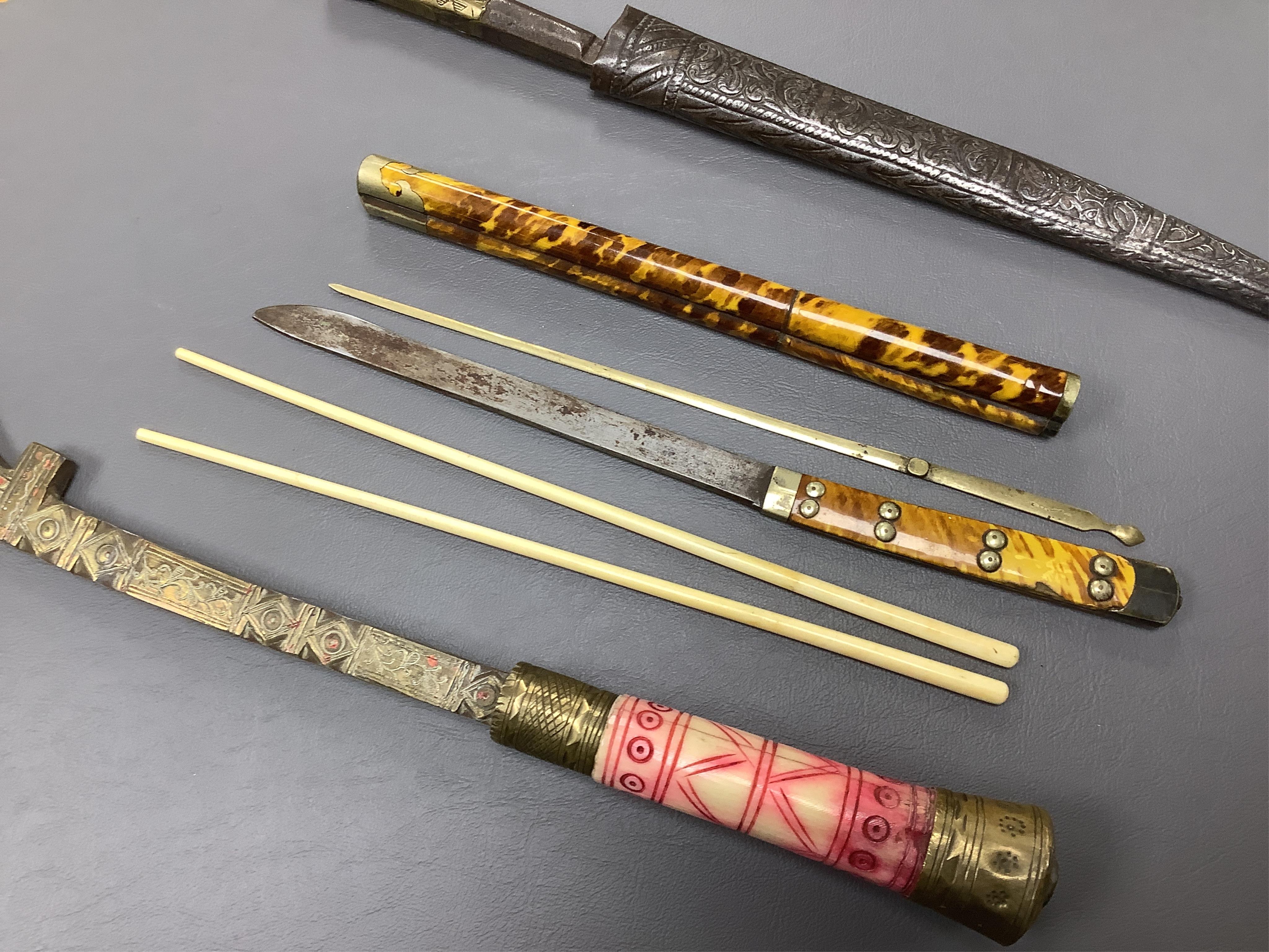 Eighteen assorted world weapons comprising a silver jambya (pommel missing), a knobkerry, a dha, two kris (one with handle missing), a lohar, three kukris, a djambok, a Chinese trousse, a chora, a flyssa, five others and